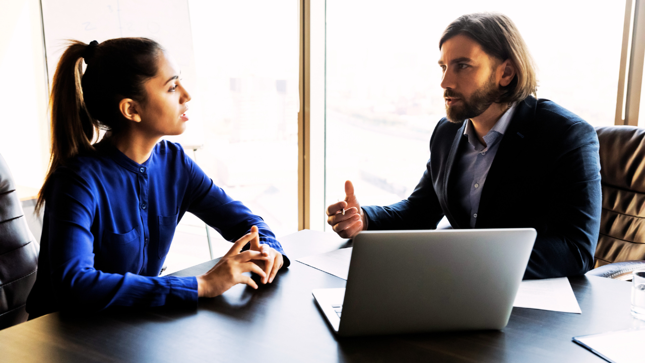 Man and a woman talking at work - soft skills for employees