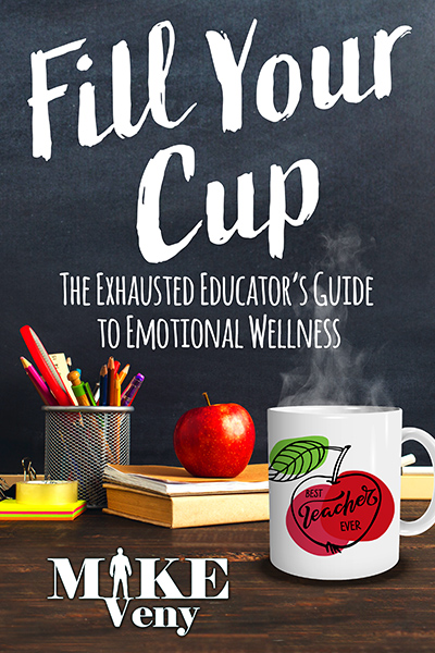 Fill Your Cup: The Exhausted Educator’s Guide to Emotional Wellness" book cover. The background features a chalkboard with the title written in large, white, handwritten-style font. Below the title, a wooden desk holds a red apple, a white mug with "Best Teacher Ever" and an apple illustration, a stack of books, and a cup filled with colorful pencils and pens. The author's name, "Mike Veny," is displayed at the bottom in bold white text with a silhouette of a person in the "I" of "Mike."