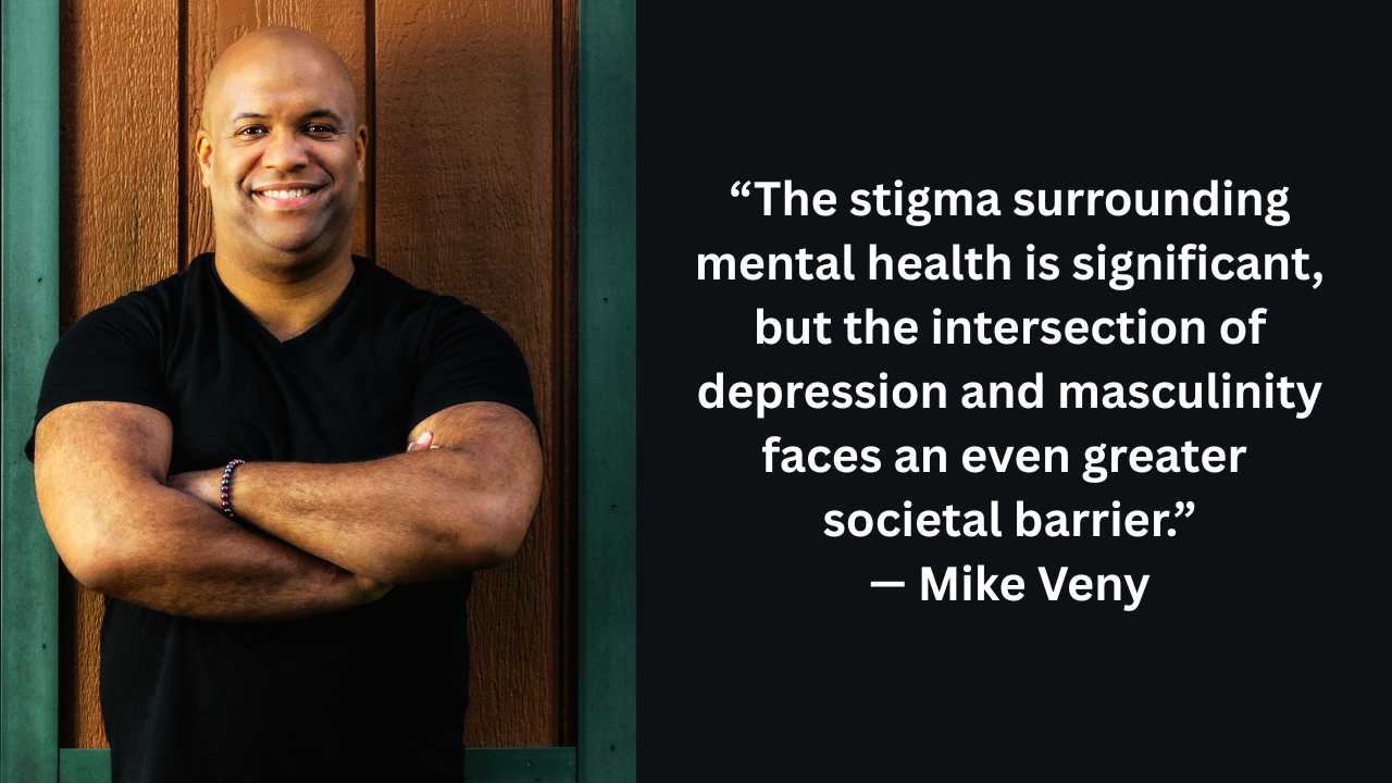 Mike Veny, a bald man with a muscular build, smiles with his arms crossed in front of a wooden and green wall. Beside him is a quote: “The stigma surrounding mental health is significant, but the intersection of depression and masculinity faces an even greater societal barrier.” — Mike Veny